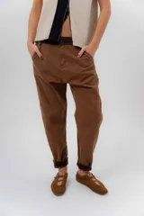 Pantalón de gabardina color marrón, con fit barrel y tiro bajo, corte relajado, bolsillos laterales y detalles de pana en la pretina y el ruedo interno.