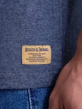 Remera de algodón color azul jaspeado, con cuello redondo, manga corta y estampa pequeña de un gato en el pecho.