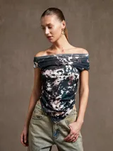 Top de escote bardot con estampado abstracto en tonos negro, blanco y marrón. Diseño ajustado con fruncido en el frente y bajo asimétrico.