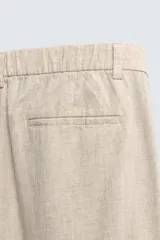 Pantalón de corte relaxed fit confeccionado en una mezcla de lyocell y lino. Presenta bolsillos frontales, bolsillos traseros de vivo y cierre frontal con cremallera y botón.
