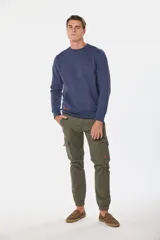 Pantalón cargo color verde militar, con bolsillos laterales y tobillos ajustados.