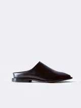 Mocasín negro de cuero con punta cuadrada y talón descubierto.