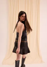 Top halter de cuero de oveja, color negro, sin mangas, con cuello alto fruncido y espalda abierta.