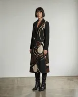 Tapado largo de diseño de autor con silueta estructurada y solapas clásicas. Presenta una estampa orgánica abstracta en tonos tierra, beige y negro, con mangas largas lisas en color negro. Cuenta con forro térmico interior para mayor abrigo.