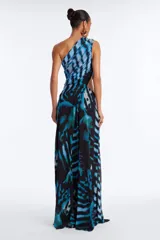 Vestido largo de fiesta con estampado etéreo en tonos azules y negros, escote asimétrico de un solo hombro con detalle cruzado y abertura en el abdomen con hebilla dorada. Presenta falda larga con tajo lateral pronunciado.