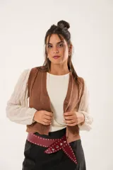 Chaleco color café de tejido sintético con escote en V y cierre frontal con botones forrados.