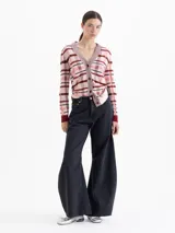 Jeans de corte wide leg y estilo balloon, color negro lavado. Presenta pinzas y recortes estratégicos en las piernas que aportan volumen y movimiento. De tiro medio, confeccionado en tejido de algodón liviano.