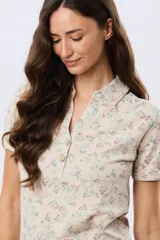 Camisa de algodón de manga corta con estampado floreado, cuello camisero y abertura frontal con botones.