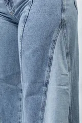 Jean wide leg azul claro con paneles de mezclilla de diferentes tonos y costuras diagonales.