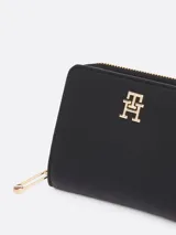 Billetera Tommy Hilfiger negra con acabado granulado, cierre de cremallera y solapa con botón a presión. Incluye compartimento interior para billetes y múltiples ranuras para tarjetas.