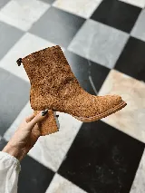 Bota corta color marrón de gamuza, con punta cuadrada, cierre lateral y taco de madera.