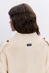 Cardigan de punto acanalado en color bordó, con cuello polo y cierre frontal de botones. Presenta un diseño de hombros caídos y mangas largas con puños ajustados.