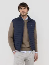 Chaleco acolchado para hombre de nylon reciclado, color verde militar, con cierre de cremallera frontal, bolsillos laterales y cuello alto.