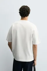 Camiseta de corte relajado confeccionada en algodón compacto, con cuello redondo y mangas cortas sin costura de sisa.