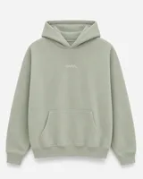 Canguro con capucha de calce oversize, confeccionado en tejido pesado color gris claro. Presenta un bordado minimalista con la palabra 'ASCEND' en la parte superior trasera, puños y ruedo acanalados.
