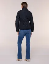 Campera capitoneada negra con costuras multidireccionales, cuello alto, cierre frontal y bolsillos laterales con cierre.