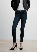 Jeans de corte skinny y tiro bajo con efecto push-up. Confeccionados en tejido elástico con diseño de cinco bolsillos, trabillas para cinturón y cierre frontal de cremallera y botón.