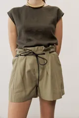 Short blanco de tiro alto, confeccionado en lino, con bolsillos laterales y cordón ajustable en la cintura.