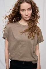 Remera negra de manga corta con cuello redondo y silueta amplia, de hombros caídos y textura suave.
