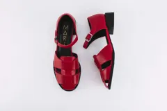 Sandalias rojas de cuero con tiras entretejidas, punta almendrada, correa con hebilla al tobillo y taco cuadrado bajo.