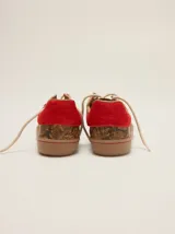Zapatillas urbanas de cuero con diseño combinado en tonos marrones con estampa de piel de serpiente y detalles en rojo, cordones beige y suela de goma.