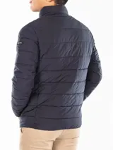 Campera puffer azul marino con cierre frontal, cuello alto y bolsillos laterales con cierre. Logo de Calvin Klein en la manga.