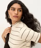 Blusa de ribana color marrón con rayas horizontales blancas, cuello medio, mangas cortas y corte ajustado.