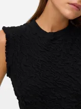 Top negro de tejido con textura, sin mangas y cuello redondo. Confeccionado en punto plano con mezcla de viscosa LENZING™ ECOVERO™ y nailon. Diseño de calce regular, textura suave y caída ligera.