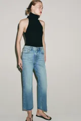 Jeans cropped flare de tiro medio color celeste, confeccionados en denim con efecto lavado. Presentan diseño de cinco bolsillos, trabillas para cinto, raya planchada al frente y bajo desflecado con terminación evasé. Cuenta con cierre frontal de cremallera y botón metálico.