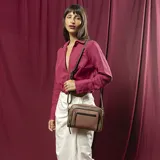 Cartera mediana de diseño rectangular, confeccionada en símil cuero con combinación de tonos tierra. Presenta dos bolsillos frontales con cierre, compartimento principal con cierre, y correa larga regulable y desmontable tipo galón. Interior forrado con bolsillos organizadores.