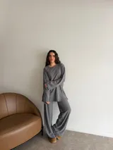 Conjunto de dos piezas de viscosa acanalada en color gris, compuesto por una remera de manga larga oversize y un pantalón largo de corte recto y holgado.