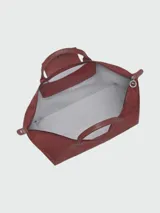 Bolso de mano tipo tote de la línea Le Pliage One de Longchamp, en color bordó. Presenta un diseño minimalista con cierre de cremallera superior, solapa con botón a presión y asas cortas de cuero.