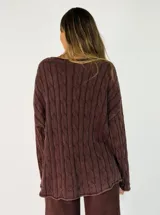 Sweater de punto con diseño de trenzas verticales, cuello redondo y corte holgado. Presenta un acabado texturizado con efecto lavado en color gris oscuro.