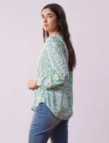 Blusa de gasa estampada con flores, marca Zac & Rachel. Tiene cuello a la base, escote en V y abertura con botones. Las mangas largas son de largo regulable.