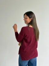 Sweater de punto en color bordó, con escote en V, mangas largas y diseño de corte recto con dobladillo ligeramente más largo en la parte posterior.