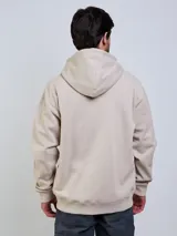 Campera con capucha Volcom modelo Lowtone, color beige, con cierre frontal completo, cordones ajustables y pequeño logo bordado en el pecho.