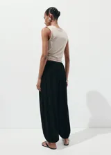 Pantalón negro de diseño balloon con tiro medio, cintura elástica y bajo con goma ajustable.
