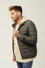 Campera acolchada tipo puffer en color verde oscuro, con cierre frontal y diseño ligero.