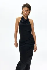 Top halter extralargo de punto elástico, color negro, con maxiescote drapeado, tiras finas para anudar al cuello y diseño asimétrico con fruncidos en los laterales.