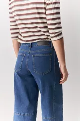 Jean de corte barrel, tiro alto, con silueta amplia que se estrecha hacia el tobillo. Confeccionado en denim azul oscuro con costuras a contratono.