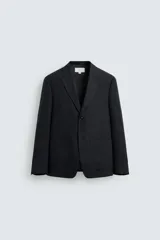 Blazer de corte relajado confeccionado en lino italiano, con cuello de solapas de muesca, cierre frontal de un botón, bolsillo de vivo en el pecho y bolsillos de plastrón en la cadera.