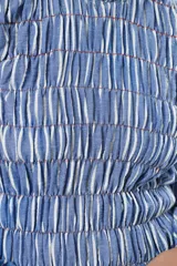 Vestido largo a rayas verticales azules y blancas, con manga globo y diseño de nido de abeja con hilo elástico hasta la cintura. Cuello alto fruncido y falda amplia con caída fluida.