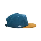 Gorra tipo snapback de corderoy con corona color terracota y visera plana color gris. Presenta un bordado frontal de un sol y el nombre de la marca bordado en el lateral.