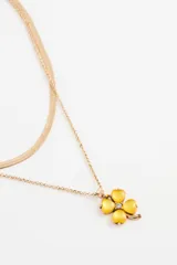 Collar doble de metal dorado, compuesto por una cadena tipo serpiente y una cadena fina con dije de trébol de cuatro hojas en acrílico verde.