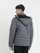 Campera puffer gris oscuro con capucha desmontable, cierre frontal con cremallera y botones a presión, bolsillos laterales con cierre y detalles en color naranja.