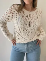 Sweater calado color crudo, de manga larga y cuello redondo.