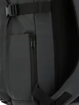Mochila urbana y outdoor marca RKF, color gris oscuro con base negra. Cuenta con compartimento principal con cierre impermeable, bolsillo para laptop de 15 pulgadas, múltiples compartimentos frontales, bolsillos laterales para botellas y correas ajustables. Incluye un llavero mosquetón decorativo y parche de cuero sintético con logo en la parte inferior.