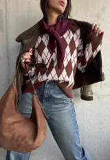 Sweater de tejido de punto con diseño de rombos en tonos chocolate, blanco y detalles en bordó. Presenta cuello redondo, mangas largas y terminaciones acanaladas en puños y ruedo.