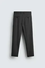 Pantalón chino negro slim fit de corte recto, con bolsillos frontales, trabillas para cinturón y cierre frontal con cremallera y botón.