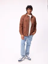 Sobrecamisa de algodón color marrón, con cierre frontal de cremallera y botones a presión. Presenta cuello clásico, dos bolsillos frontales con solapa y cierre de botón, y forro interior de poliéster.